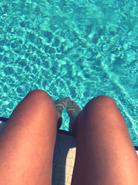 Low section of woman relaxing in swimming pool