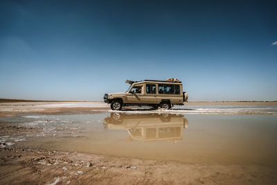 Toyota landcruiser driving through puddle in the desert with reflection 2