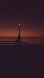 Silhouette of boat against sea at sunset