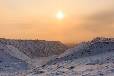 Scenic view of snow covered mountains against sky during sunset