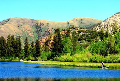 Scenic view of lake and mountains against clear sky