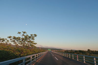 Empty road against clear blue sky