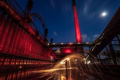 Man spinning wire wool at factory during night