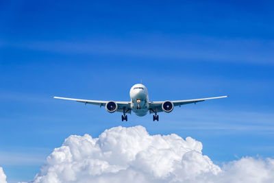 Low angle view of airplane flying against blue sky