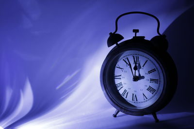 Close-up of alarm clock against wall