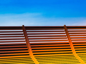 Wooden sun lounger at the beach or on a cruise ship against sunny blue sky.