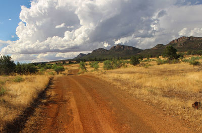 Dirt road amidst landscape against sky, flinders rangers australia