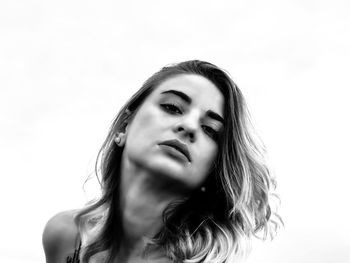 Close-up portrait of young woman against white background