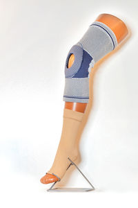 A knee brace on the mannequin's leg for stabilization and relief of the knee joint.