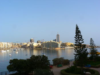 Buildings in city against clear sky