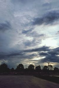 Road by city against sky at dusk