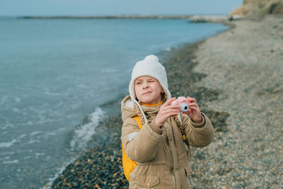 Portrait of young woman standing at beach