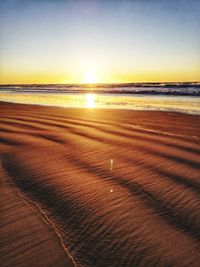 Scenic view of beach against sky during sunset