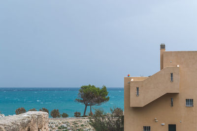 Scenic view of sea and buildings against clear sky