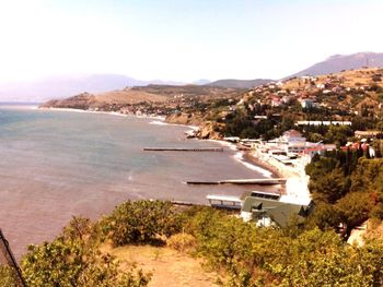 High angle view of cityscape by sea against sky