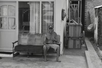 Full length of man sitting on sofa