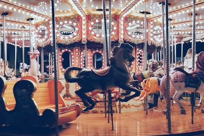 View of illuminated carousel at amusement park