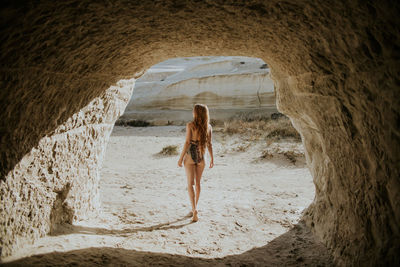 Rear view of woman walking on beach