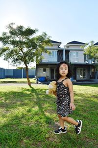 Full length portrait of woman standing on field