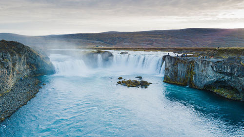 Scenic view of waterfall against sky