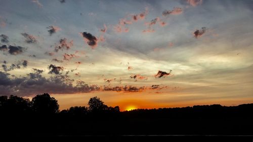 Scenic view of dramatic sky over silhouette landscape