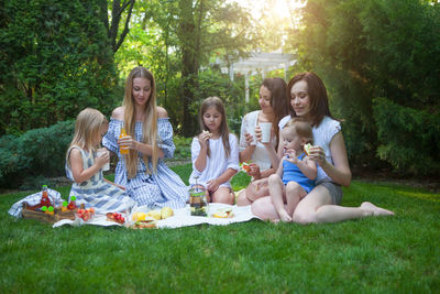 Group of people sitting on grassland