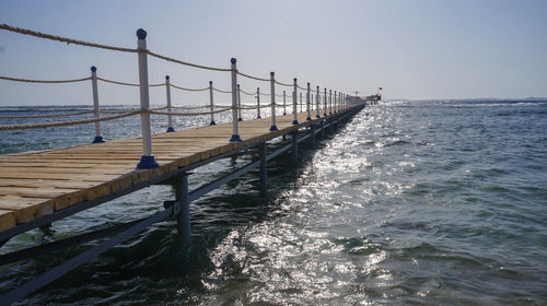 Pier over sea against clear sky