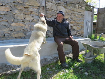 Full length of man sitting outdoors