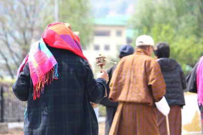 Rear view of people standing against blurred background