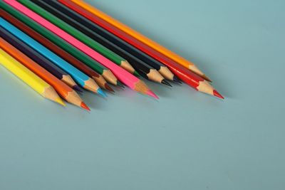 High angle view of colored pencils against white background