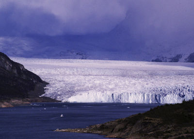 Scenic view of landscape by sea against sky