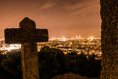 Illuminated cityscape against sky at sunset