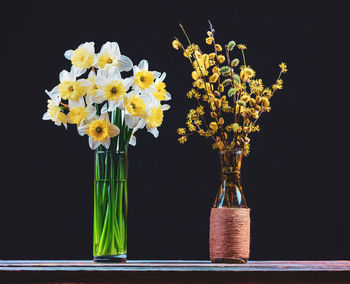 Close-up of yellow flower vase against black background