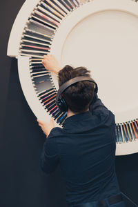 Rear view of man playing piano