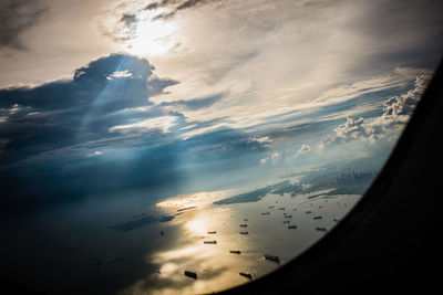 Aerial view of sea and landscape against sky during sunset