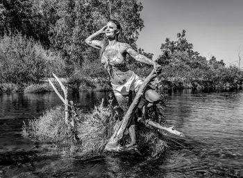 Close-up of young woman against plants in lake