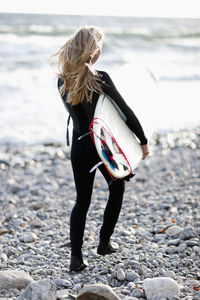 Rear view of woman standing at beach