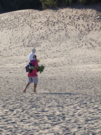 Rear view of woman walking on shore