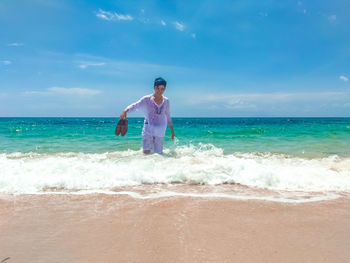 Man standing at beach against sky