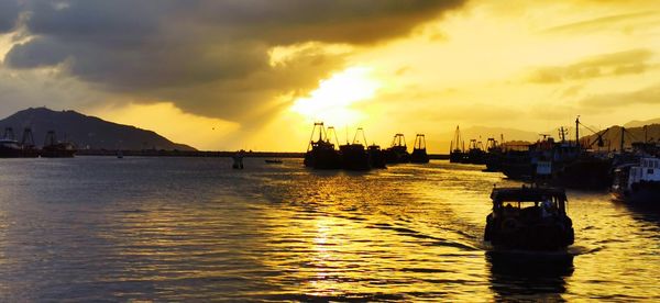 Sailboats in sea against sky during sunset