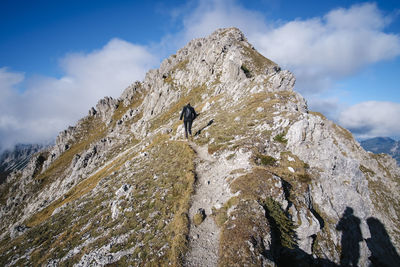 Rear view of woman walking on mountain ridge