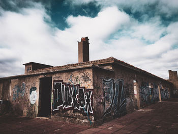 Graffiti on old building against sky