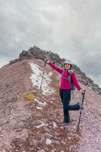 Rear view of man standing on mountain against sky