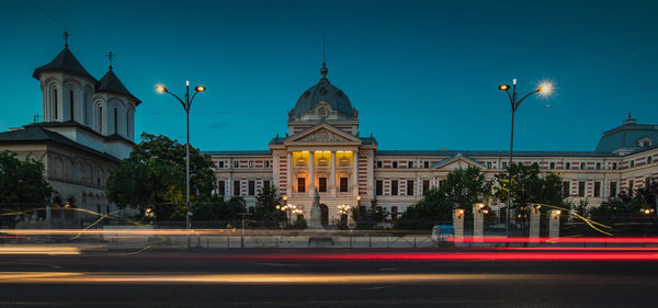 Light trails on street against buildings at night