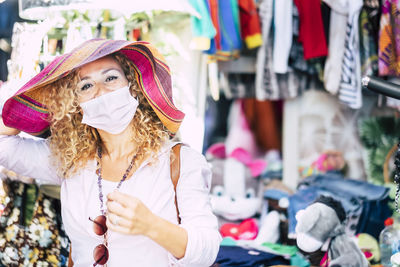 Portrait of woman wearing mask standing at market