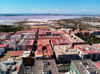 High angle view of city by sea against sky