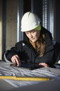 Female engineer checking plans on digital tablet