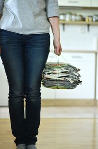 Midsection of woman holding bundle of old papers