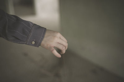 Cropped hand of man holding thread