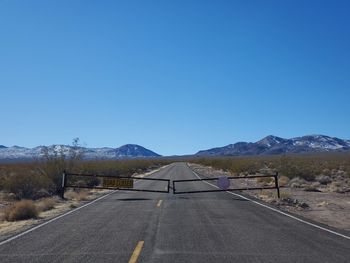 Road by mountain against blue sky